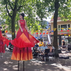Steltenloper met een lang rood-oranje kostuum